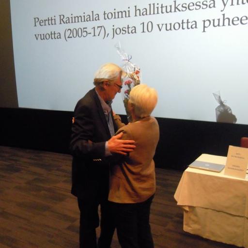 Pertti Raimiala sai vuosikokouksessa kutsun SGS:n kunniapuheenjohtajaksi ja siitä kukkaset ja halauksen SGS:n Anneli Tuomiselta.