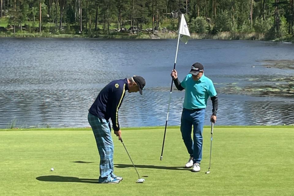 Keijo Lehtokorpi puttaamassa ja Ossi Smolander avustamassa vaikealla par 3 väylällä 12.