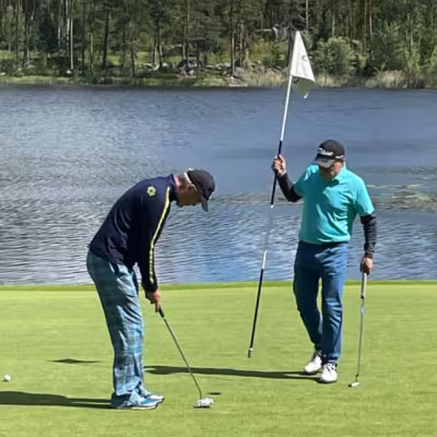 Keijo Lehtokorpi puttaamassa ja Ossi Smolander avustamassa vaikealla par 3 väylällä 12.